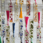 Decorative bookmarks with floral and tassel designs on a textured surface